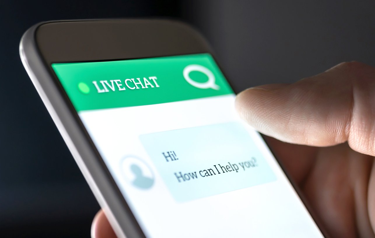 close-up-of-hand-holding-smartphone-displaying-live-chat-conversation-on-website